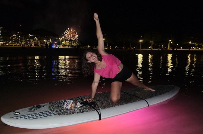 Night SUP Yoga and Fireworks at Magic Island - LED-lit water and the Honolulu skyline at night